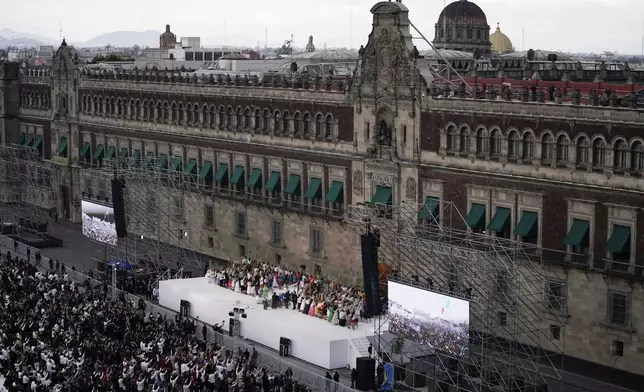 President Claudia Sheinbaum waves to Indigenous women during a rally in the Zócalo, Mexico City's main square, on her inauguration day, Tuesday, Oct. 1, 2024. (AP Photo/Aurea Del Rosario)