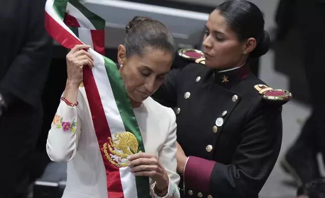 President Claudia Sheinbaum puts on the presidential sash during her swearing in ceremony as Mexico's new president in Mexico City, Tuesday, Oct. 1, 2024. (AP Photo/Fernando Llano)