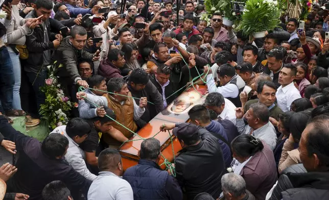 Residents use ropes to lower the coffin of slain Catholic priest and activist Marcelo Pérez, into a grave in the church courtyard of San Andrés Larráinzar, Chiapas state, Mexico, Tuesday, Oct. 22, 2024. (AP Photo/Isabel Mateos)