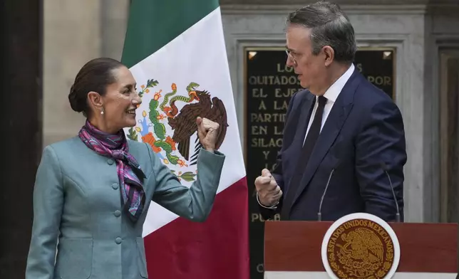 Mexican President Claudia Sheinbaum, left, speaks with her Economy Secretary Marcelo Ebrard during a news conference at the National Palace in Mexico City, Tuesday, Oct. 15, 2024. (AP Photo/Fernando Llano)