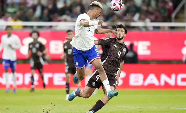 The United States' Antonee Robinson, left, heads the ball past Mexico's Raúl Jiménez during an international friendly soccer match at Akron Stadium in Guadalajara, Mexico, Tuesday, Oct. 15, 2024. (AP Photo/Eduardo Verdugo)