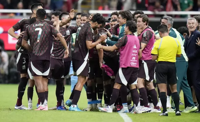 Mexico's Raúl Jiménez, in light-blue cleats, is congratulated after scoring his side's opening goal against the United States during an international friendly soccer match at Akron Stadium in Guadalajara, Mexico, Tuesday, Oct. 15, 2024. (AP Photo/Eduardo Verdugo)