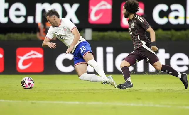 The United States' Joe Scally, left, falls over challenged by Mexico's César Huerta during an international friendly soccer match at Akron Stadium in Guadalajara, Mexico, Tuesday, Oct. 15, 2024. (AP Photo/Eduardo Verdugo)