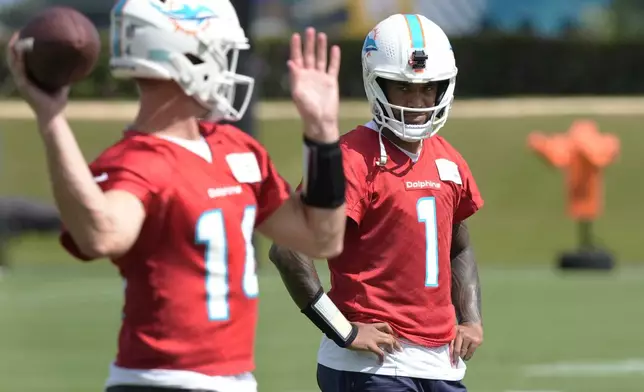 Miami Dolphins quarterback Tua Tagovailoa (1) watches Tim Boyle during a practice session at the team's training facility, Wednesday, Oct. 23, 2024, in Miami Gardens, Fla. (AP Photo/Marta Lavandier)