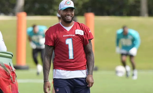 Miami Dolphins quarterback Tua Tagovailoa (1) smiles during a practice session at the team's training facility, Wednesday, Oct. 23, 2024, in Miami Gardens, Fla. (AP Photo/Marta Lavandier)