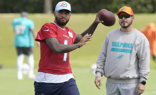 Miami Dolphins quarterback Tua Tagovailoa (1) aims a pass during a practice session at the team's training facility, Wednesday, Oct. 23, 2024, in Miami Gardens, Fla. (AP Photo/Marta Lavandier)