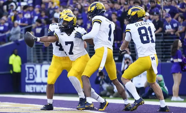 Michigan running back Donovan Edwards (7) reacts with wide receiver Amorion Walker (1) and wide receiver Peyton O'Leary (81) after scoring a touchdown against Washington during the first half of an NCAA college football game Saturday, Oct. 5, 2024, in Seattle. (AP Photo/Lindsey Wasson)