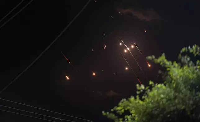 Missiles launched from Iran towards Israel streak across the night sky as seen from Deir al-Balah, Gaza Strip, Tuesday, Oct. 1, 2024. (AP Photo/Abdel Kareem Hana)