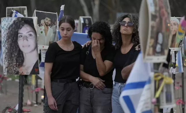 People react during a ceremony at the site of the Nova music festival, where hundreds of revelers were killed and abducted by Hamas and taken into Gaza, on the one-year anniversary of the attack, near Kibbutz Reim, southern Israel, Monday, Oct. 7, 2024. (AP Photo/Ariel Schalit)