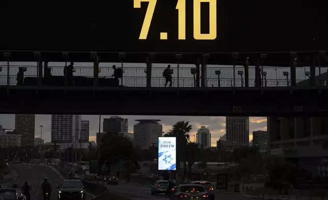 People cross a bridge with the date 7.10, marking the one-year anniversary of the Hamas attack on Israel, in Ramat Gan, Israel, Sunday, Oct. 6, 2024. (AP Photo/Oded Balilty)