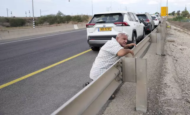 Residents seek shelter as sirens blaring announce imminent attack near the Gaza border, as Israel marks the one-year anniversary of the Hamas attack on Israel on Monday, Oct. 7, 2024. (AP Photo/Ohad Zwigenberg)