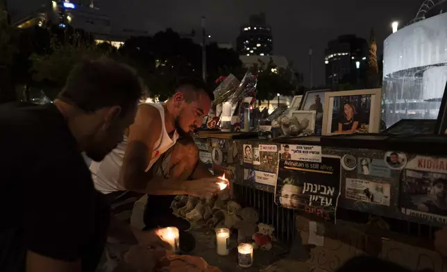 People light candles at a memorial for the victims of the Oct. 7 Hamas cross-border attack on Israel, on the eve of the one-year anniversary of the attack, in Tel Aviv, Israel, Sunday, Oct. 6, 2024. (AP Photo/Oded Balilty)