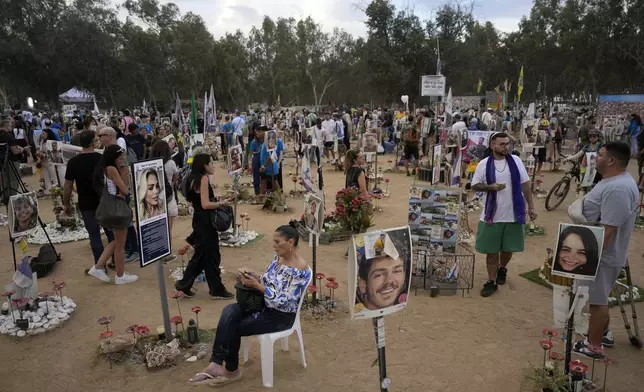 People visit the site of the Nova music festival, where hundreds of revelers were killed and abducted by Hamas and taken into Gaza, on the one-year anniversary of the attack, near Kibbutz Reim, southern Israel, Monday, Oct. 7, 2024. (AP Photo/Ariel Schalit)