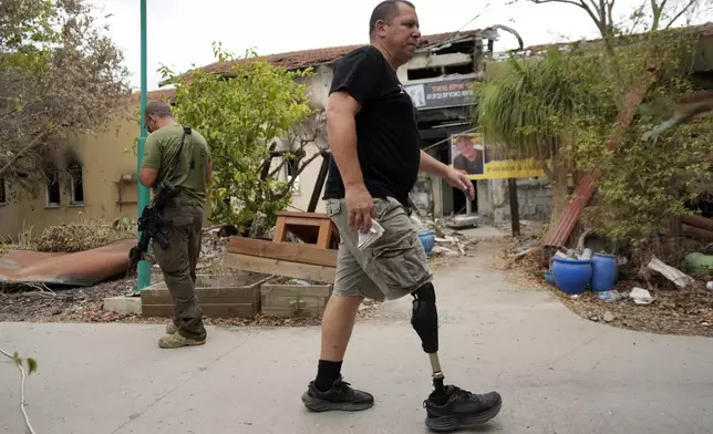 A man walks at the Kibbutz Be'eri, an Israeli communal farm on the Gaza border, as Israel marks the one-year anniversary of the Hamas attack on Israel on Monday, Oct. 7, 2024. (AP Photo/Ohad Zwigenberg)