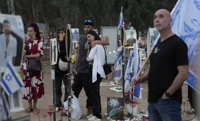 People react during a ceremony at the site of the Nova music festival, where hundreds of revelers were killed and abducted by Hamas and taken into Gaza, on the one-year anniversary of the attack, near Kibbutz Reim, southern Israel, Monday, Oct. 7, 2024. (AP Photo/Ariel Schalit)