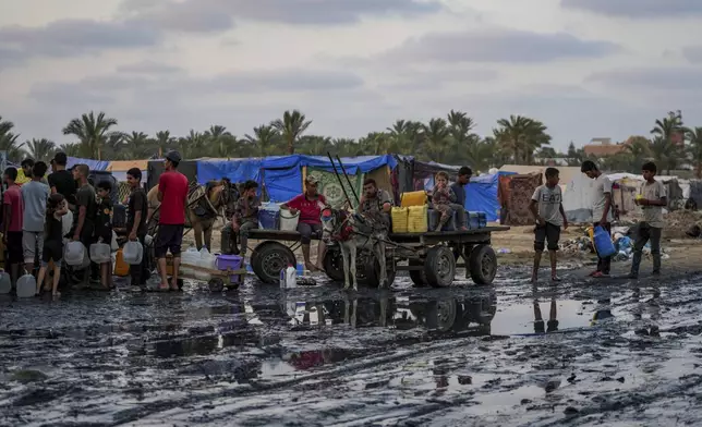 FILE - Palestinians gather to fill water jugs near one of the strip's few functioning desalination plants in Deir al-Balah, Gaza Strip, Thursday, June 20, 2024. (AP Photo/Abdel Kareem Hana, File)