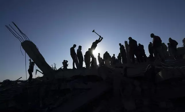 FILE - Palestinians search for bodies and survivors in the rubble of a house destroyed in an Israeli airstrike, in Rafah, southern Gaza Strip, Sunday, Jan. 7, 2024. (AP Photo/Fatima Shbair, File)