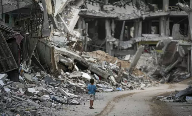 A child walks through the destruction left by the Israeli air and ground offensive on Khan Younis, Gaza Strip, Thursday, Sept. 12, 2024. (AP Photo/Abdel Kareem Hana)