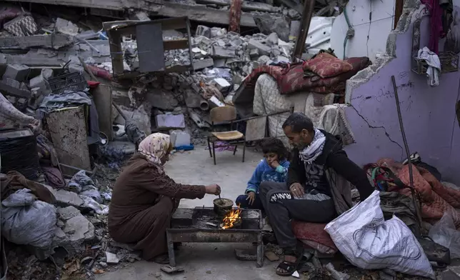 FILE - Members of the Al-Rabaya family break their fast during the Muslim holy month of Ramadan outside their home destroyed by Israeli airstrikes in Rafah, Gaza Strip, Monday, March 18, 2024. (AP Photo/Fatima Shbair, File)