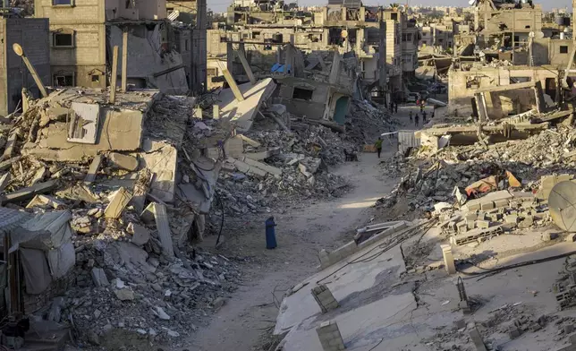 Palestinians walk through the destruction left by the Israeli air and ground offensive on Khan Younis, Gaza Strip, Thursday, Sept. 12, 2024. (AP Photo/Abdel Kareem Hana)