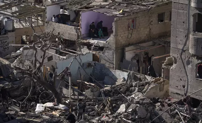 FILE - Palestinians look at the destruction after an Israeli strike on residential buildings and a mosque in Rafah, Gaza Strip, Thursday, Feb. 22, 2024. (AP Photo/Fatima Shbair, File)