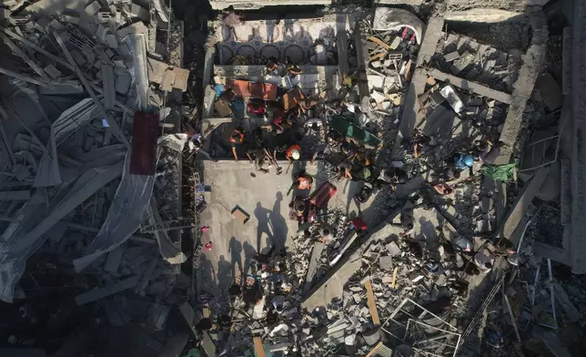 FILE - Palestinians inspect the rubble of buildings hit by an Israeli airstrike at Al Shati Refugee Camp Thursday, Oct. 12, 2023. (AP Photo/Hatem Moussa, File)