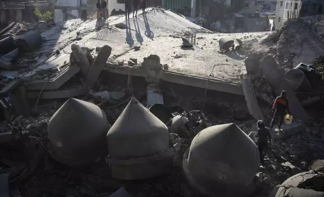 FILE - Palestinians look at the destruction after an Israeli strike on residential buildings and a mosque in Rafah, Gaza Strip, Thursday, Feb. 22, 2024. (AP Photo/Fatima Shbair, File)