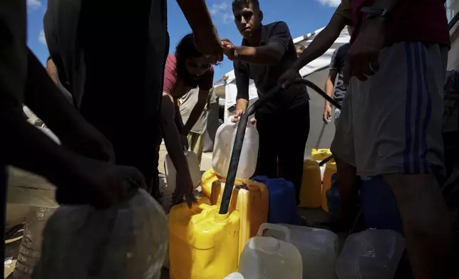 Displaced Palestinians line up to collect water at a makeshift tent camp in Khan Younis, Gaza Strip, Saturday, Sept. 21, 2024. (AP Photo/Abdel Kareem Hana)