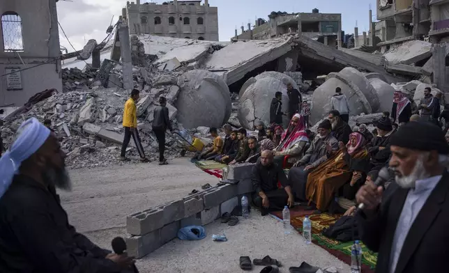 FILE - Palestinians pray in front of a mosque destroyed by the Israeli airstrikes in Rafah, Gaza Strip, Friday, March 8, 2024, ahead of the holy Islamic month of Ramadan. (AP Photo/Fatima Shbair, File)