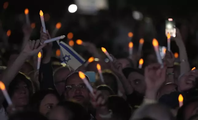 Members of the Jewish community wave electronic candles as they gather at a park in Sydney, Australia, on Monday, Oct. 7, 2024, as mourners marked the anniversary of the Oct. 7, 2023, Hamas attack. (AP Photo/Rick Rycroft)