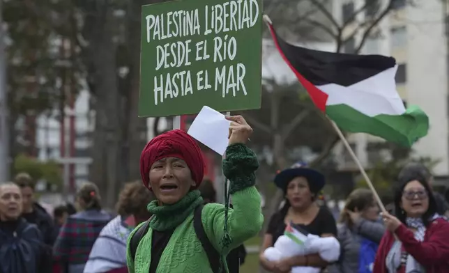 A pro-Palestinian demonstrator holds a sign that reads in Spanish, "Freedom for Palestine, from the river to the sea," during a march in Lima, Peru, Monday, Oct. 7, 2024. (AP Photo/Guadalupe Pardo)