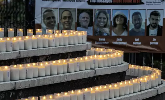 People light 1200 candles in front of the synagogue in Duesseldorf, Germany, Monday, Oct. 7, 2024, marking the first anniversary of the Oct. 7, 2023 attacks on Israel. (AP Photo/Martin Meissner)