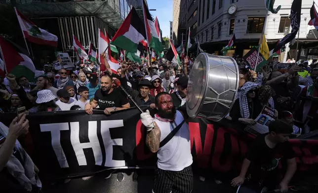 A man bangs a drum during a march as pro-Palestinian supporters rally in Sydney, Sunday, Oct. 6, 2024. (AP Photo/Rick Rycroft)