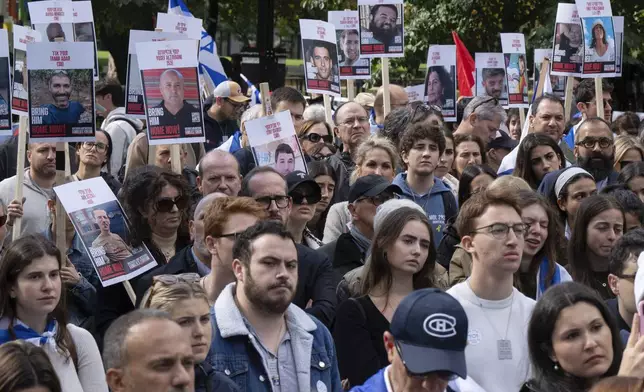 People hold pictures of hostages as they attend a pro-Israel vigil on the anniversary of a Hamas attack on Israel that triggered the ongoing war in Gaza in front of McGill University in Montreal, Canada, Monday, Oct. 7, 2024. (Ryan Remiorz/The Canadian Press via AP)