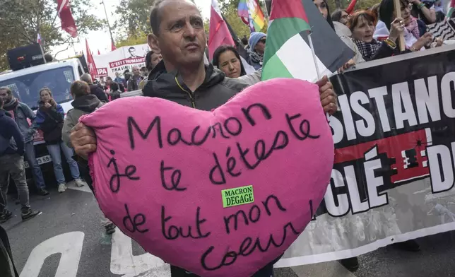 A protester holds a a cushion that reads, "Macron I hate you with all my heart " during rally in support of Palestinian people in Gaza and Lebanon in Paris, Saturday, Oct. 5, 2024. (AP Photo/Michel Euler)