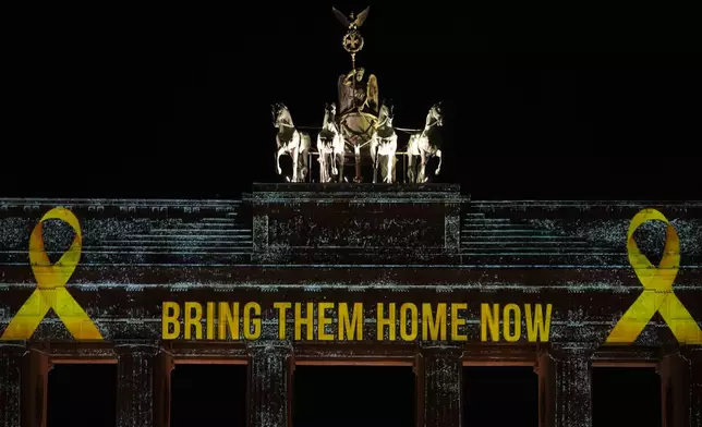 The Brandenburg Gate is illuminated in solidarity with Israel, marking the first anniversary of the Hamas spearheaded attacks on Israel, in Berlin, Germany, Monday, Oct. 7, 2024. (AP Photo/Markus Schreiber)