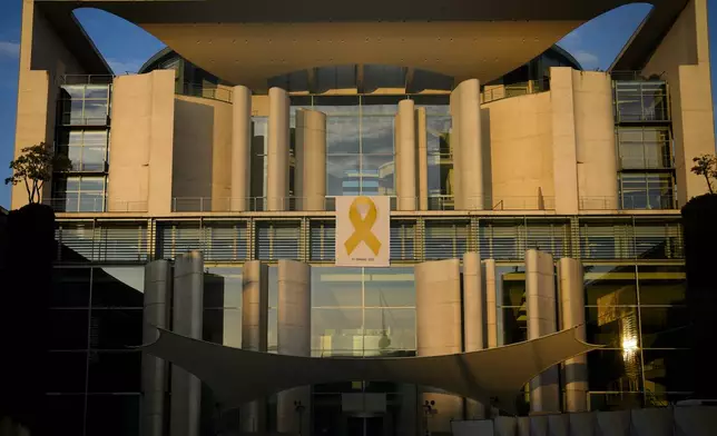 A Yellow Ribbon displayed as the facade of the German Chancellor to show solidarity with Israel marking the first anniversary of the Hamas spearheaded attacks on Israel, in Berlin, Germany, Monday, Oct. 7, 2024. (AP Photo/Markus Schreiber)