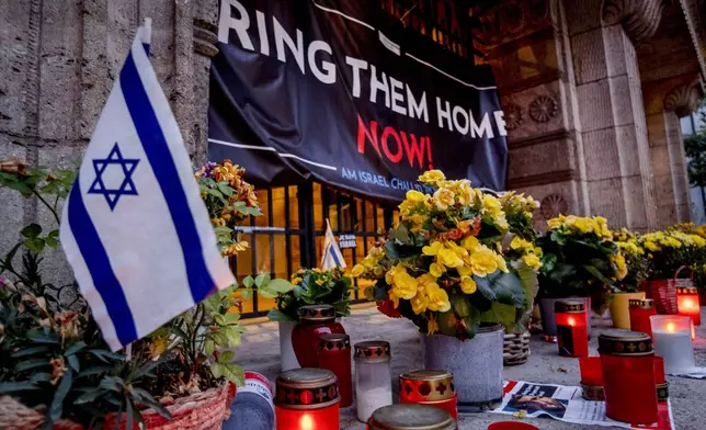 Candles and flowers are laid at the entrance of the synagogue to mark the first anniversary of the Hamas attack on Israel, Frankfurt, Germany, Monday, Oct. 7, 2024. (AP Photo/Michael Probst)