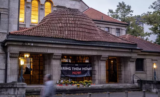 Candles and flowers are laid at the entrance of the synagogue to mark the first anniversary of the Hamas attack on Israel, Frankfurt, Germany, Monday, Oct. 7, 2024. (AP Photo/Michael Probst)