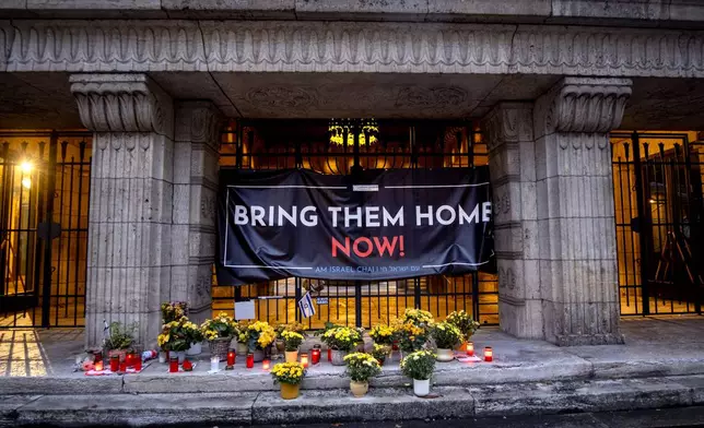 Candles and flowers are laid at the entrance of the synagogue to mark the first anniversary of the Hamas attack on Israel, Frankfurt, Germany, Monday, Oct. 7, 2024. (AP Photo/Michael Probst)