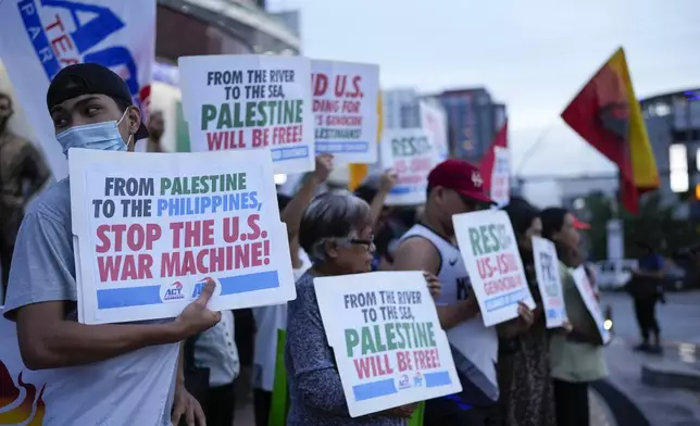 Activists hold signs during a pro-Palestinian rally held to mark the one-year anniversary of the Israel Hamas war on Monday, Oct. 7, 2024, in Quezon City, Philippines. (AP Photo/Aaron Favila)