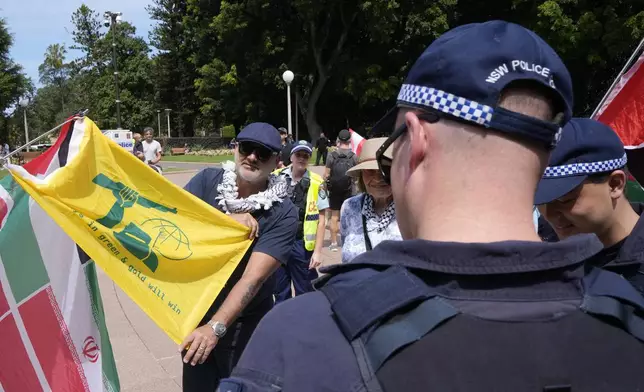 Police officers inspect a flag as pro-Palestinian supporters rally in Sydney, Sunday, Oct. 6, 2024. (AP Photo/Rick Rycroft)