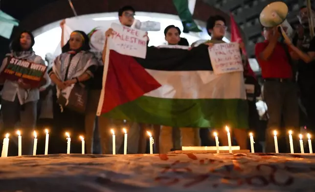 Activists light candles as they hold a pro-Palestinian rally to mark the one-year anniversary of the Israel Hamas war on Monday Oct. 7, 2024, in Quezon City, Philippines. (AP Photo/Aaron Favila)