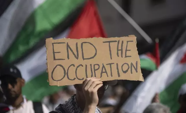 A Moroccan man carries a sign during a protest in support of Gaza and Lebanon, in Rabat, Morocco, Sunday, Oct. 6, 2024 (AP Photo/Mosa'ab Elshamy)