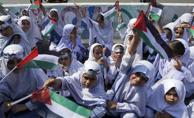 School children take part in a rally organized by Pakistan Markazi Muslim League party, to protest against Israeli airstrikes and to show solidarity with Palestinian people living in Gaza and Lebanon, in Karachi, Pakistan, Monday, Oct. 7, 2024. (AP Photo/Fareed Khan)