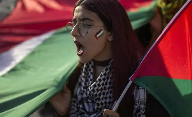 A demonstrator hold a Palestinian flag and chants slogans during a pro Palestinian protest in Istanbul, Turkey, Saturday, Oct. 5, 2024. (AP Photo/Khalil Hamra)