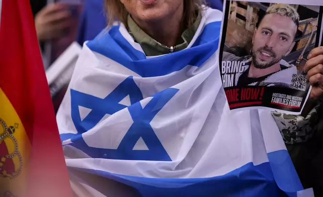 An activist holds a picture of the hostage during a commemoration to mark the one-year anniversary of the Israel Hamas war in Madrid, Spain, Monday, Oct. 7, 2024. (AP Photo/Manu Fernandez)