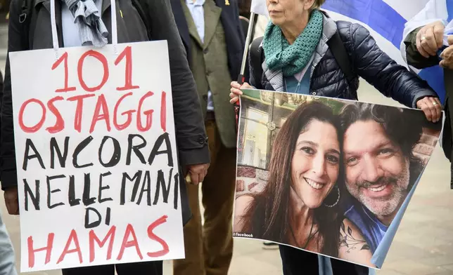 People attend a flash mob for the release of hostages and demand a ceasefire on the one year anniversary of the Israel Hamas war, at San Babila Square, in Milan, Monday, Oct. 7, 2024. Writing on sign reads in Italian "101 hostages still in the hands of Hamas." (Claudio Furlan/LaPresse via AP)