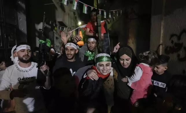 Aseel al-Titi, wearing a Hamas headband, a former Palestinian prisoner who was released by the Israeli authorities, is greeted by friends and family members in Balata, a Palestinian refugee camp in Nablus, West Bank, Friday, Nov. 24, 2023. (AP Photo/Majdi Mohammed)