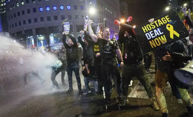 Police use water cannons to disperse demonstrators during a protest against Israeli Prime Minister Benjamin Netanyahu's government, and calling for the release of hostages held in the Gaza Strip by the Hamas militant group, in Tel Aviv, Israel, Saturday, Feb. 24, 2024. (AP Photo/Ohad Zwigenberg)